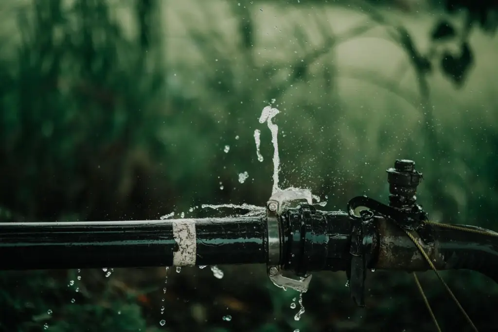 Water spraying from a leaking outdoor pipe