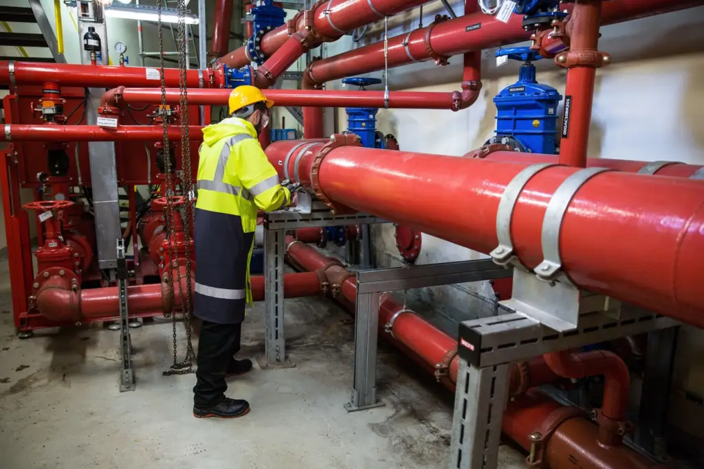 Plumber working on a large pipe with a hand tool